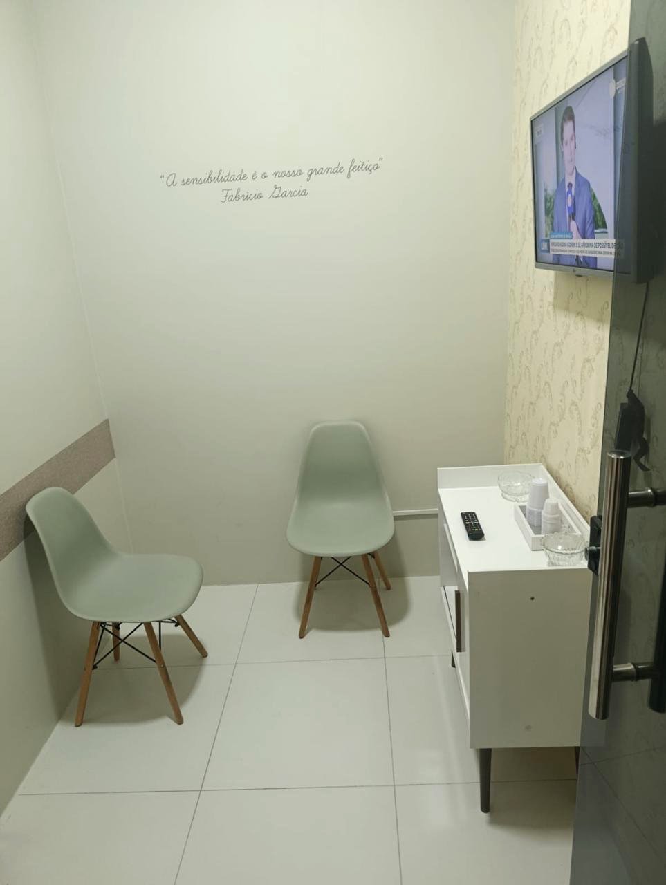 Sala de espera com cadeiras e televisão